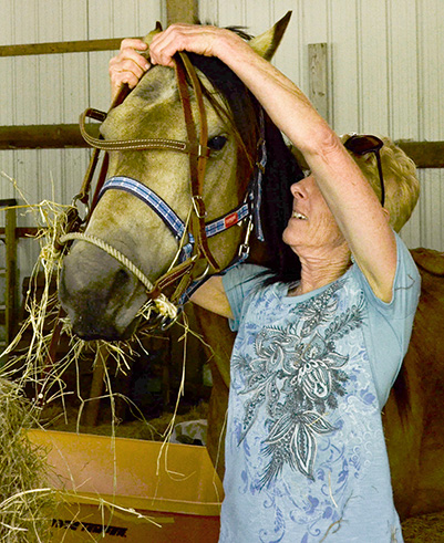 Blair Wells prepares horse for riding